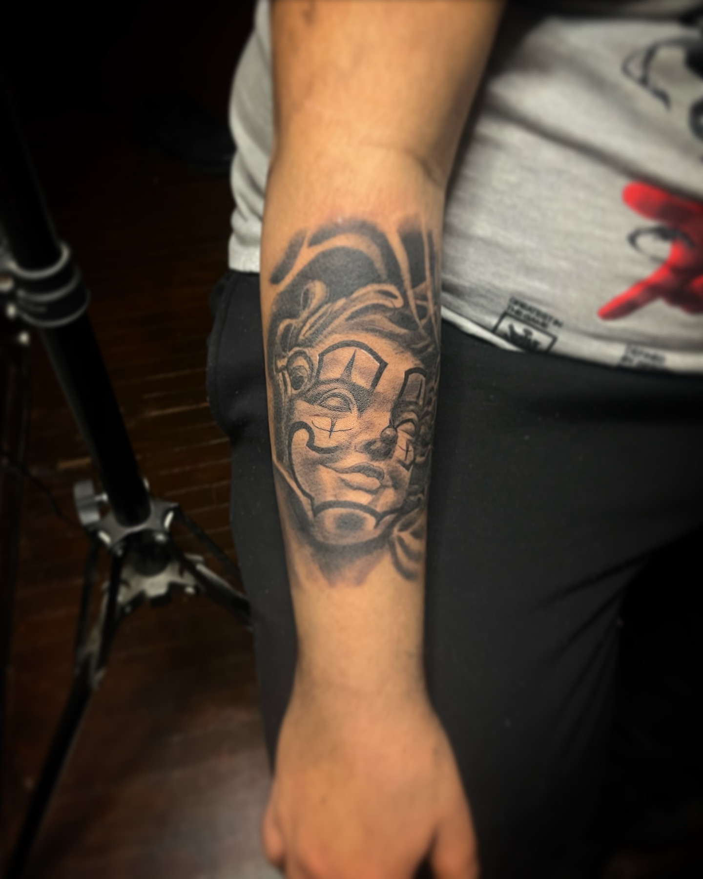 Mask black and grey tattoo on the forearm by Brandon Patino