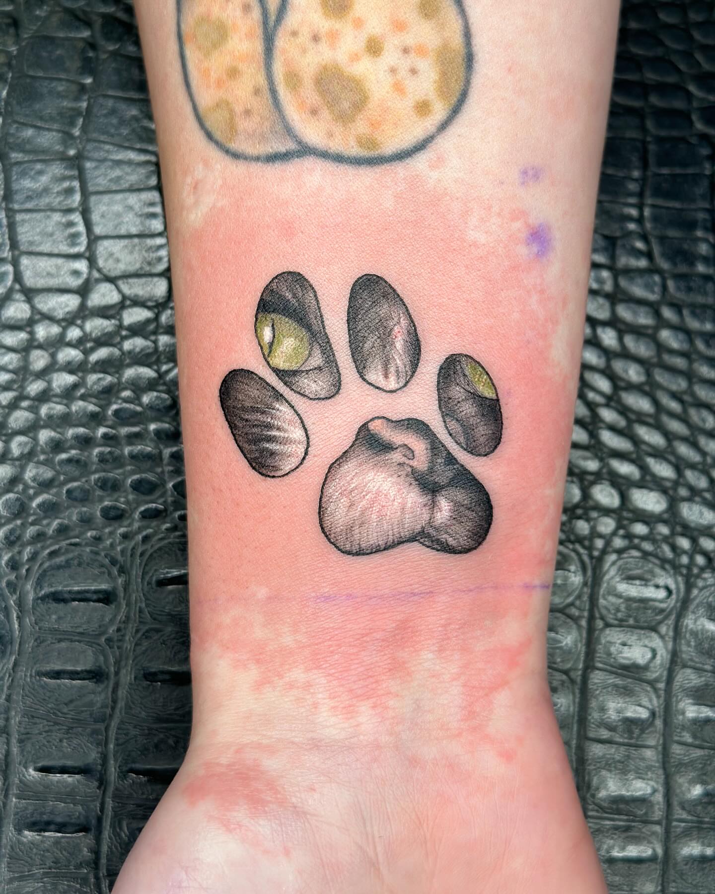 Paw print realism tattoo on the foot by Hi