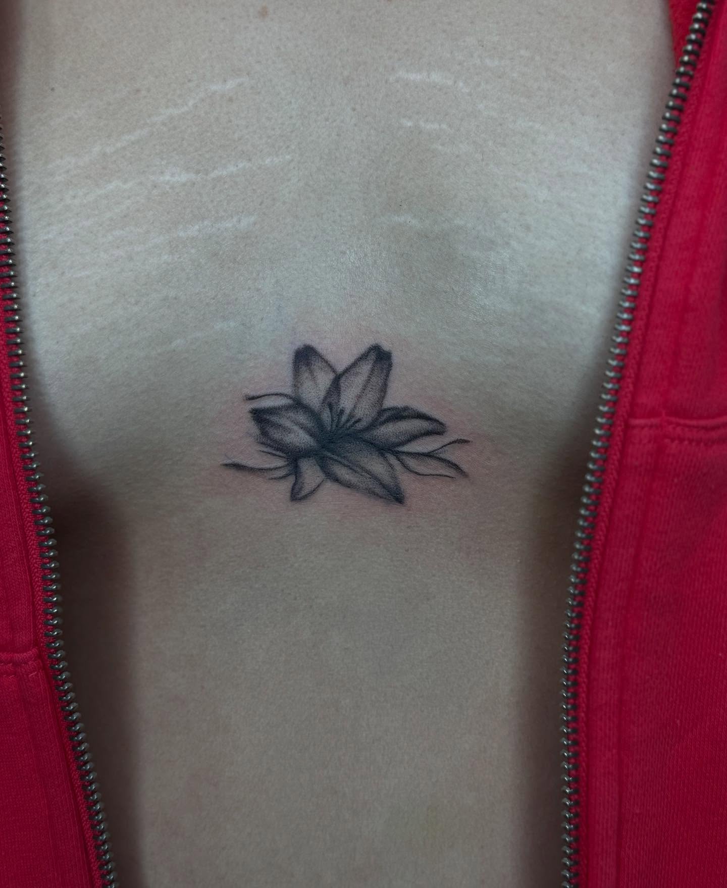 Lotus flower black and grey tattoo on the chest by Alexa Camacho
