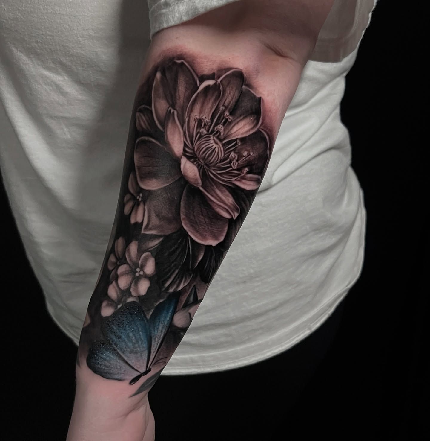 Flowers and butterfly realism tattoo on the forearm by Chelsea Speirs