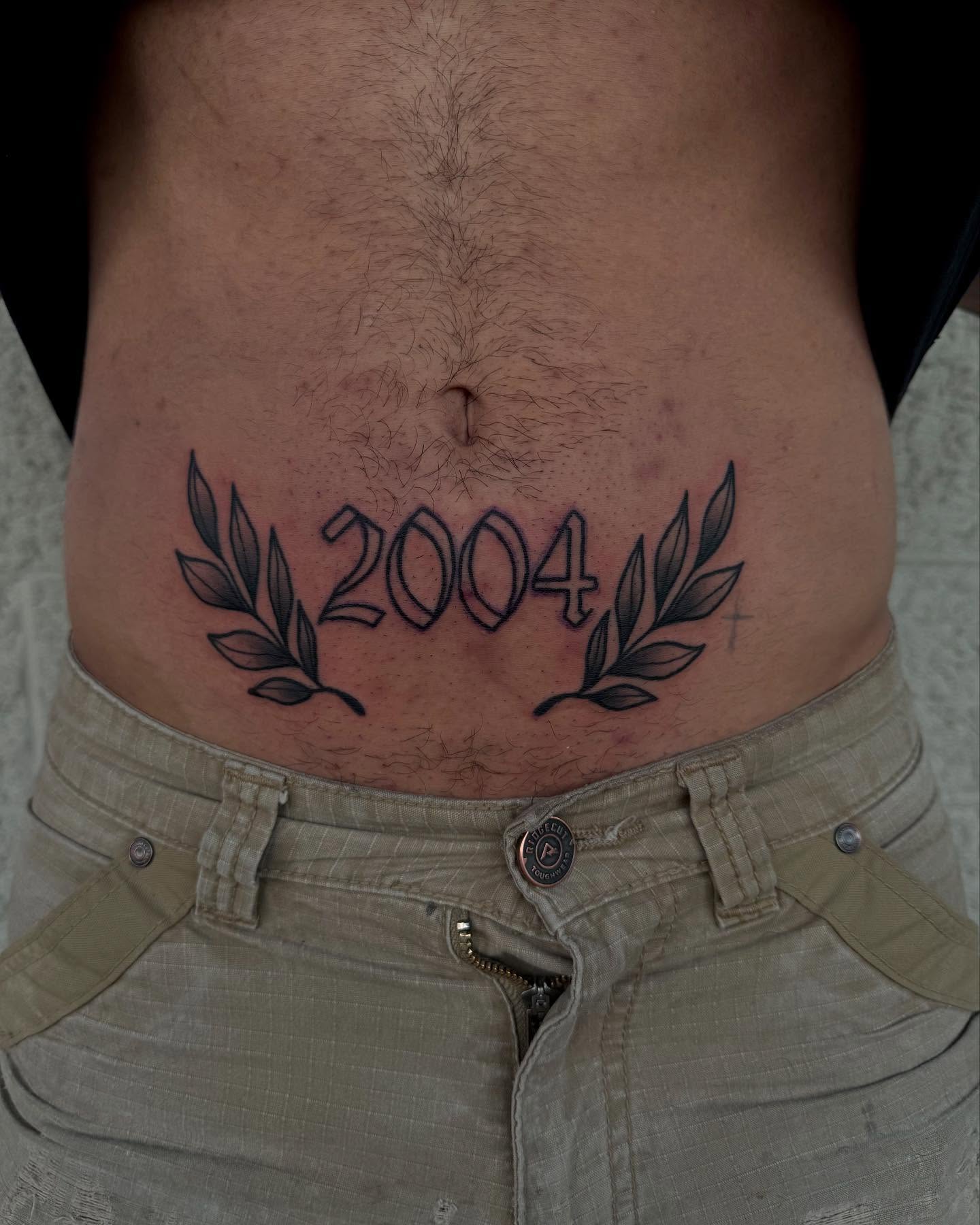 Year 2004 black and grey tattoo on the torso by Kylee langford 🧿