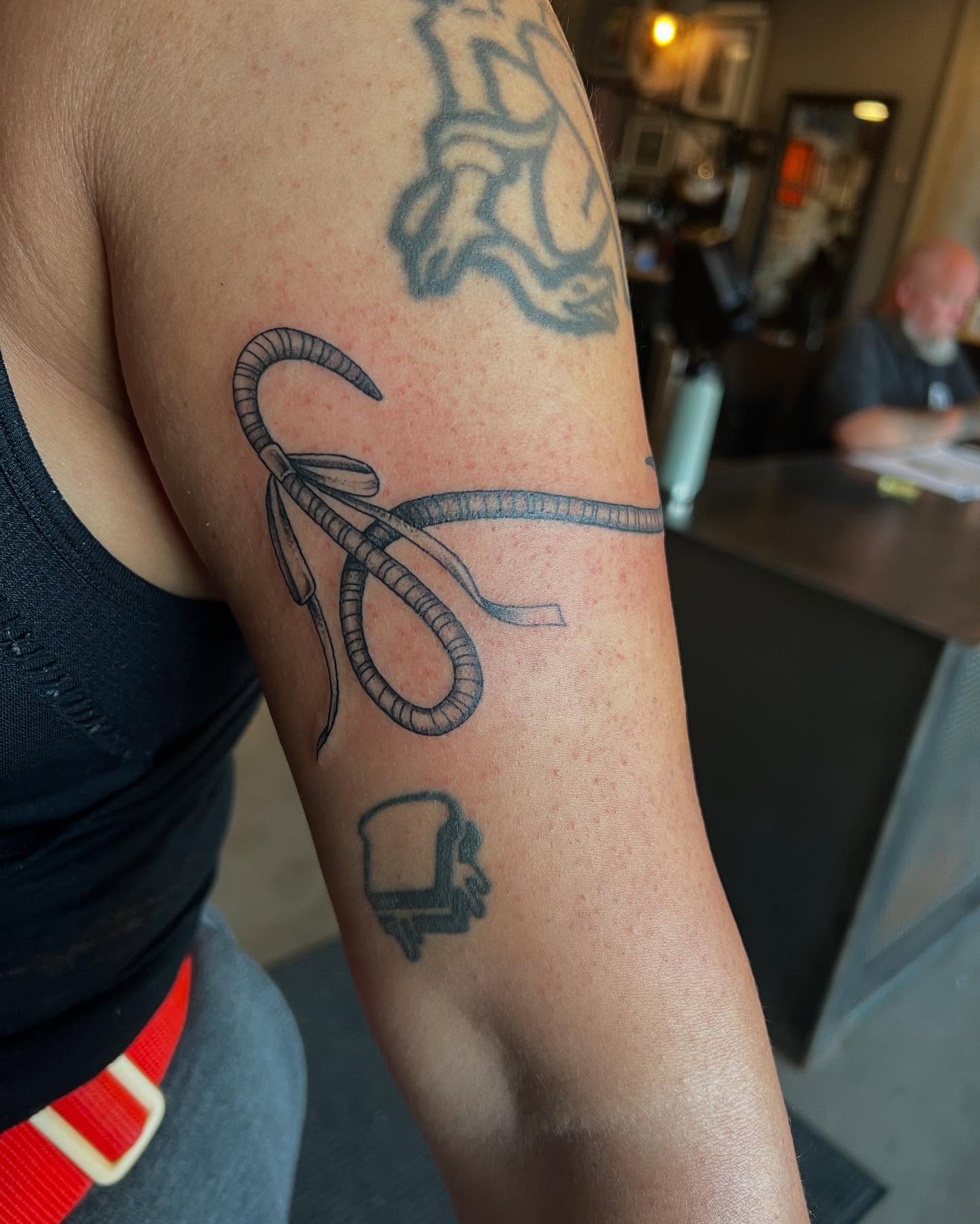 Bow and string black and grey tattoo on the forearm by Siërra Nicole, Minneapolis, Minnesota