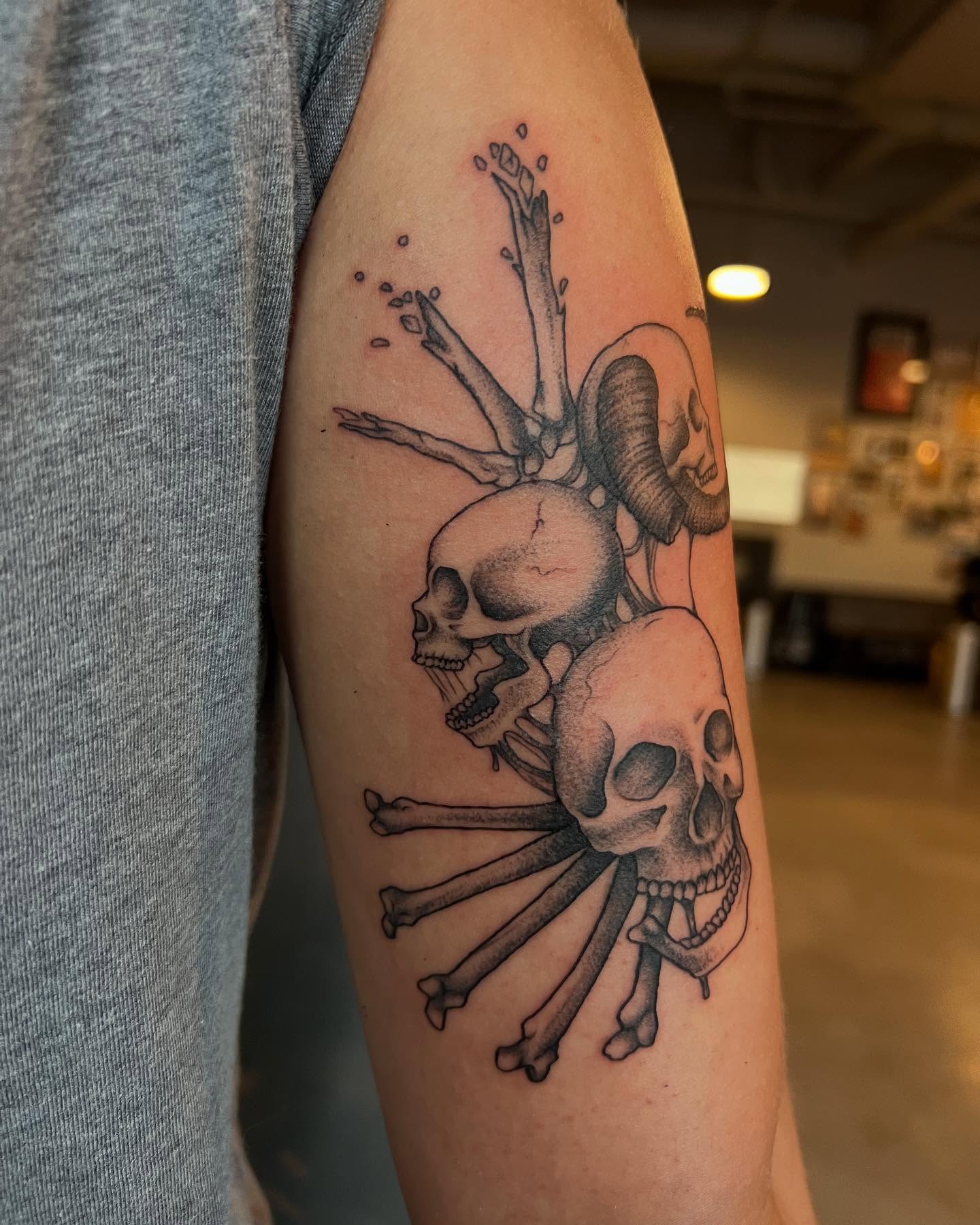 Skulls and bones black and grey tattoo on the forearm by Siërra Nicole, Minneapolis, Minnesota