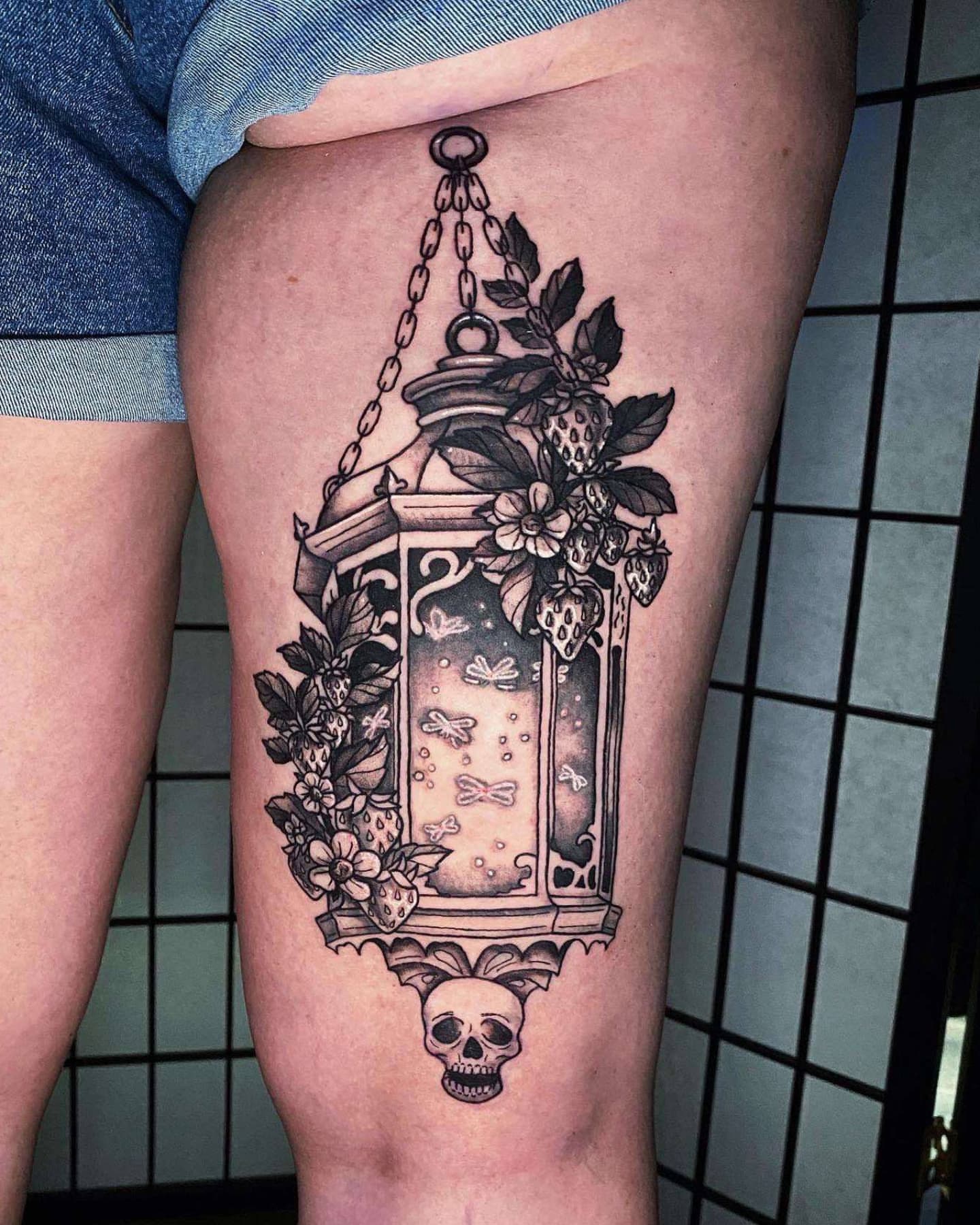Lantern with floral and insect motifs ornamental tattoo on the thigh by Tattoo Artist