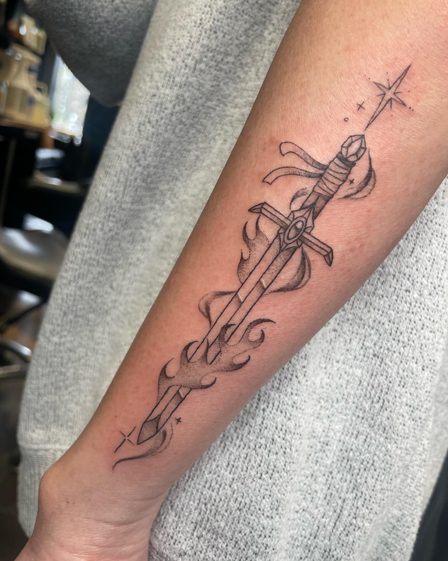 Sword and flame black and grey tattoo on the forearm by madison, Cincinnati