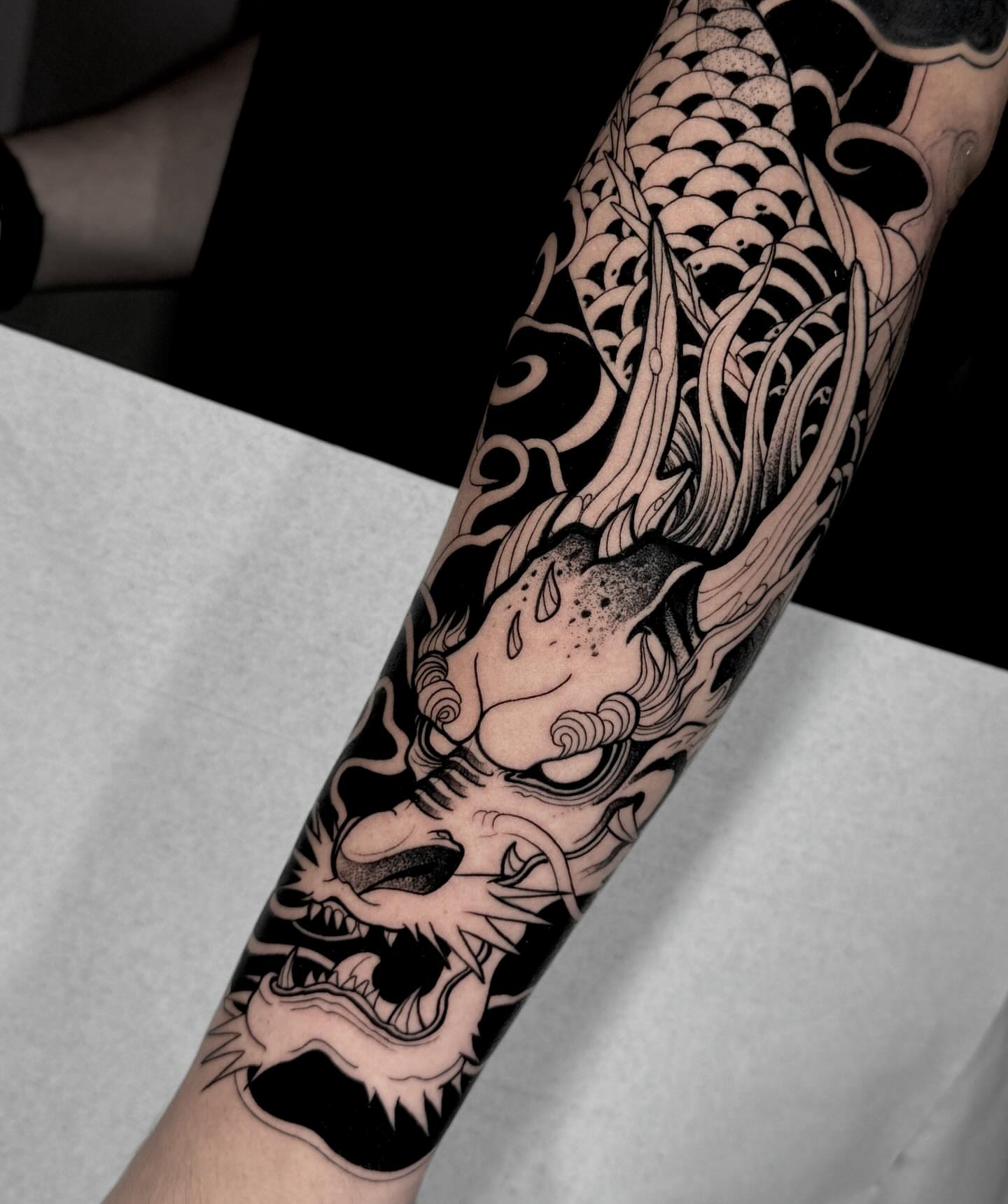 Koi fish black and grey tattoo on the forearm by Stiven Gomez