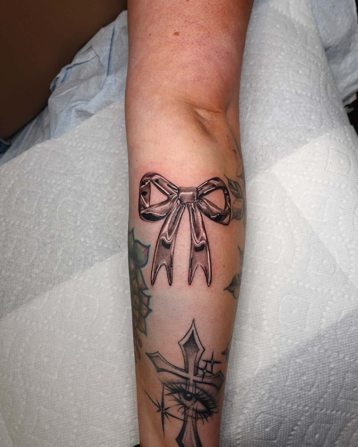 Bow black and grey tattoo on the forearm by Tat by Brendan