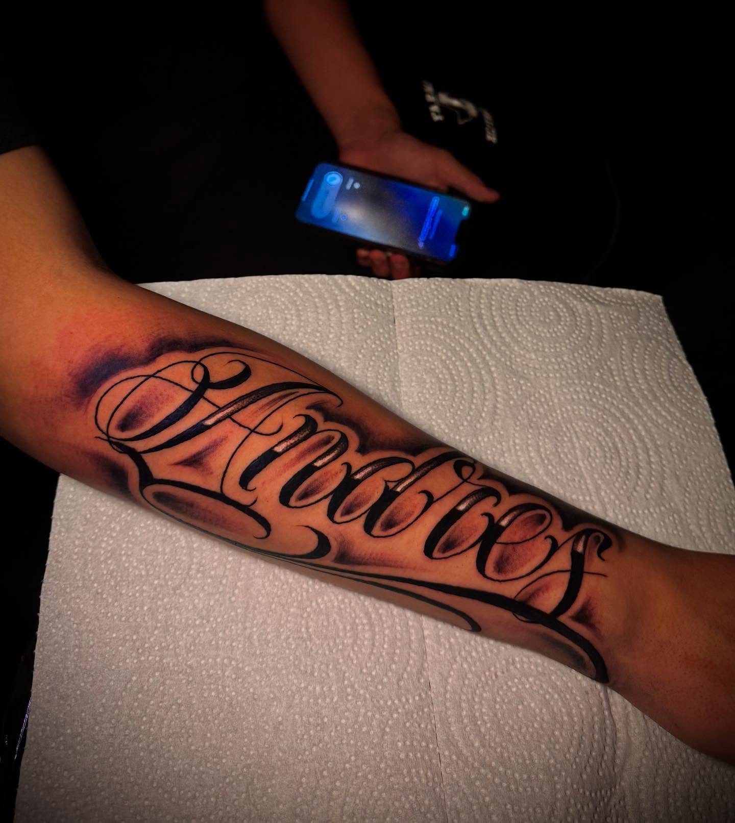 Script lettering lettering script tattoo on the forearm by Tattoo Artist based in Dallas Tx