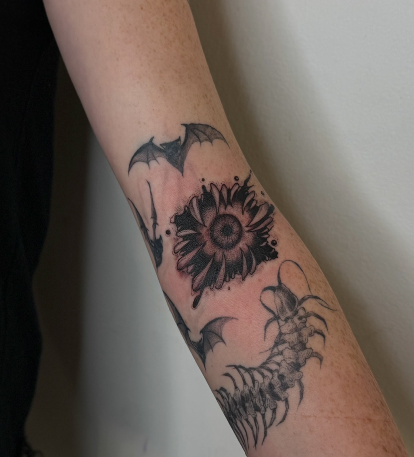 Sunflower and bats dotwork tattoo on the forearm by Dee, San Diego, California