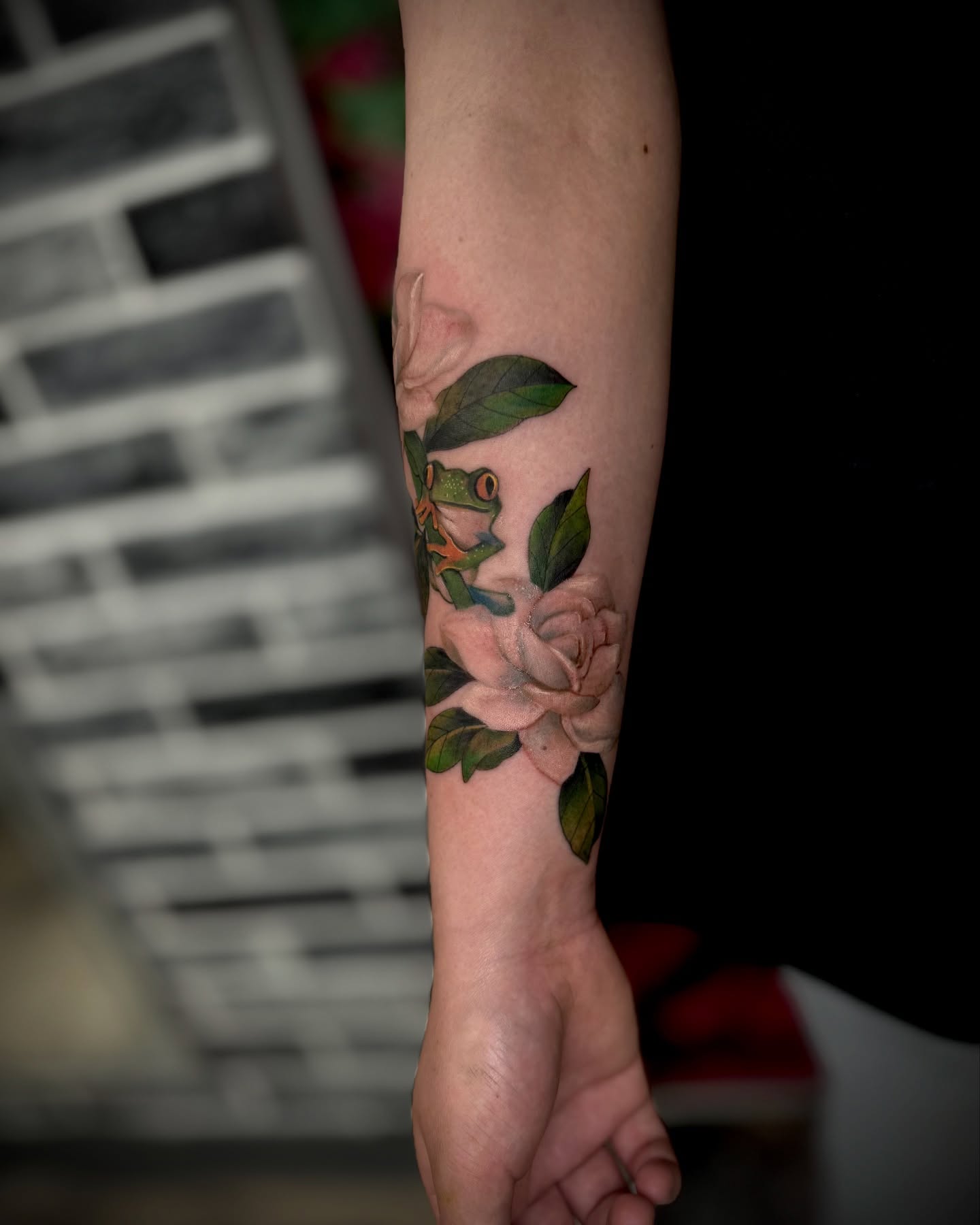Frog and rose realism tattoo on the forearm by Mitsuko Ching