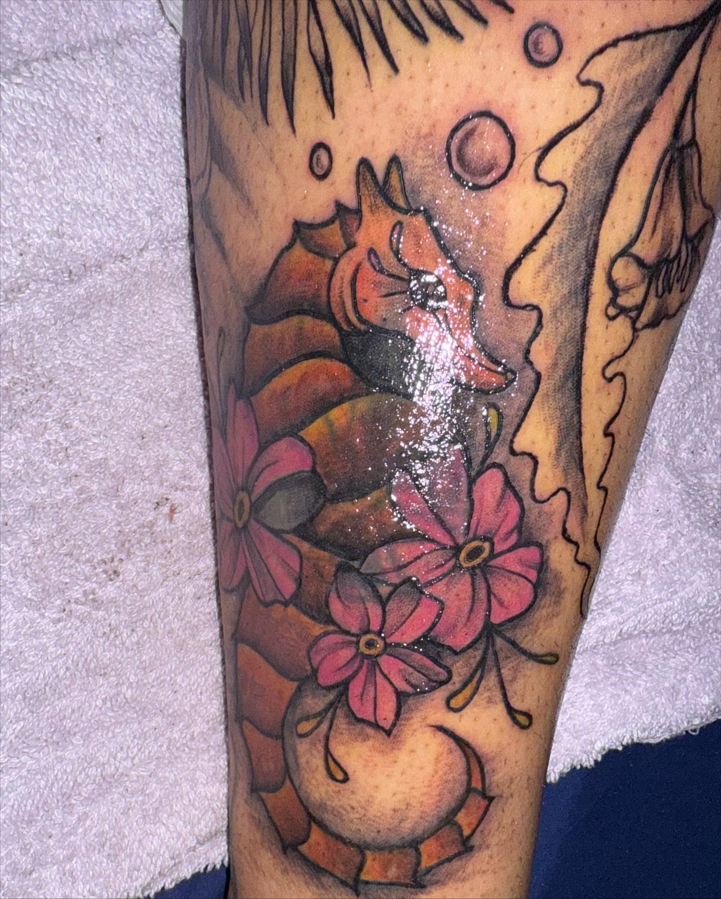 Seahorse and flowers American traditional tattoo on the leg by Aja Marie