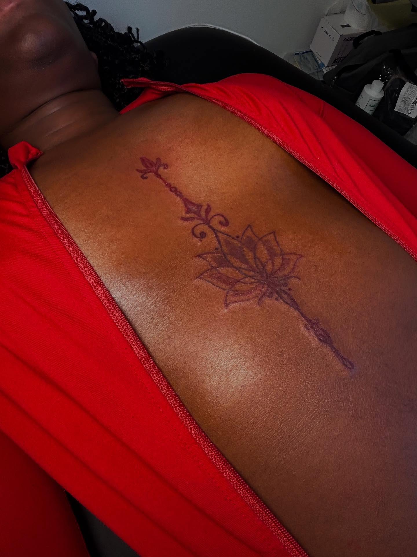 Lotus flower with arrow geometric tattoo on the back by Mc X Happo