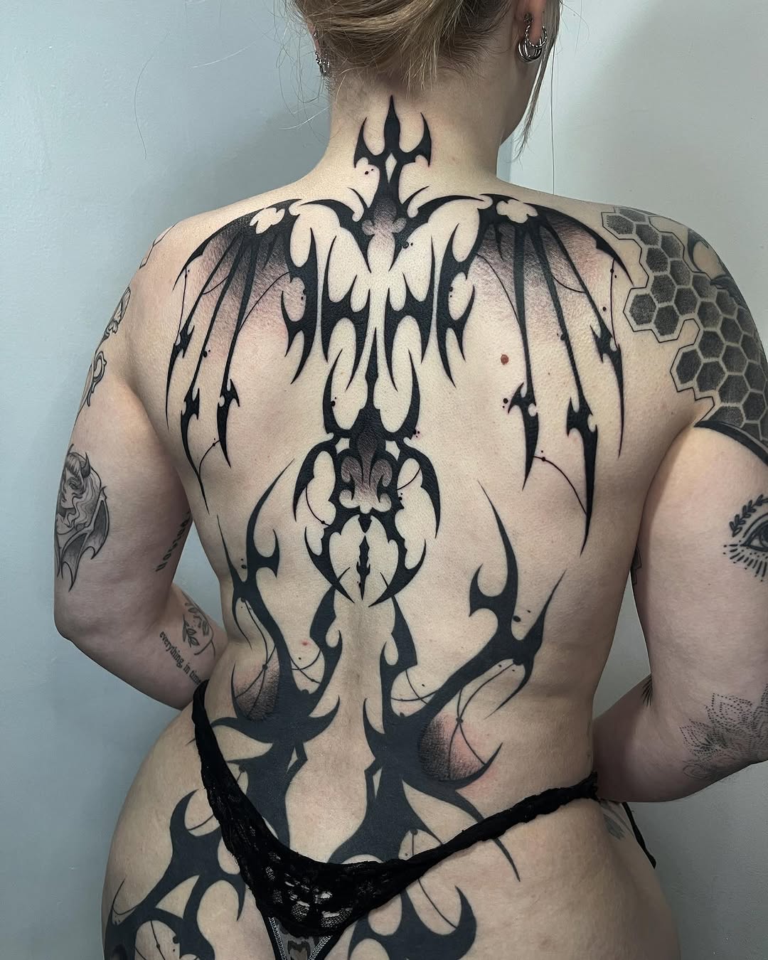 Tribal bat wings blackwork tattoo on the back by Ty’s Tattoos