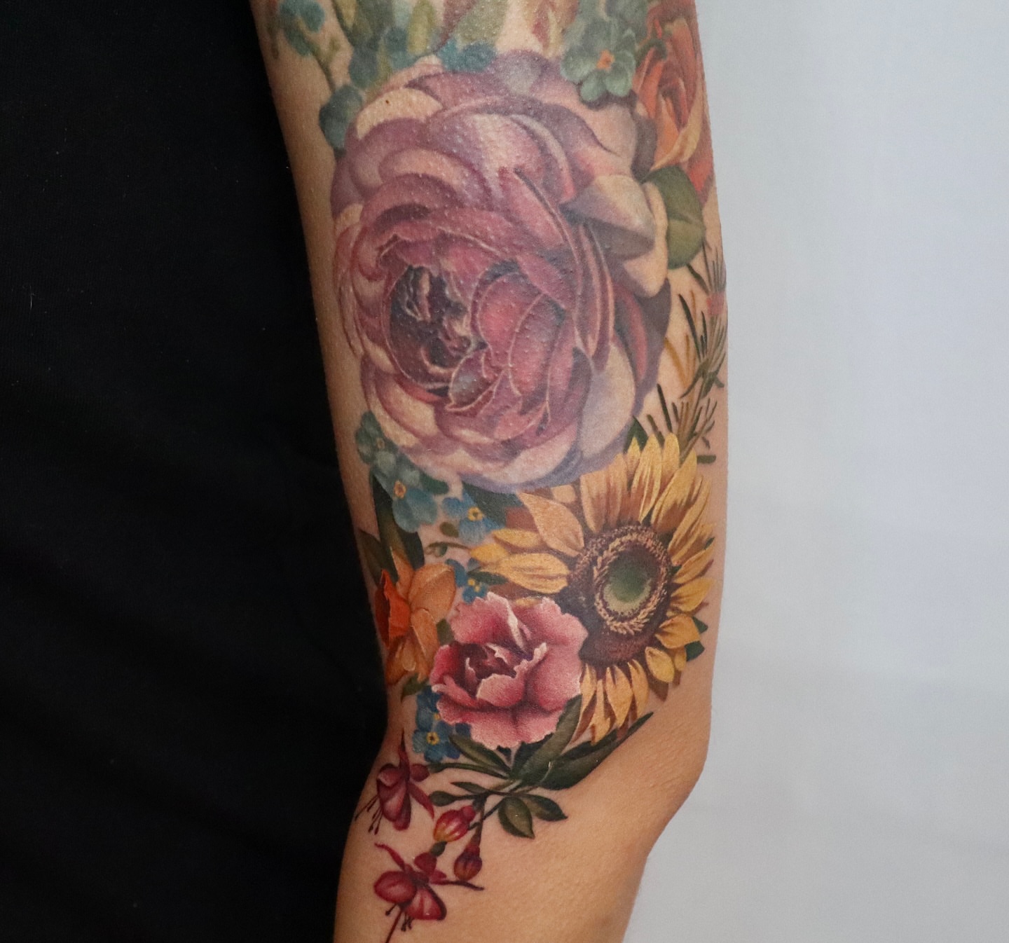 Floral bouquet watercolor tattoo on the forearm by Anali De Laney