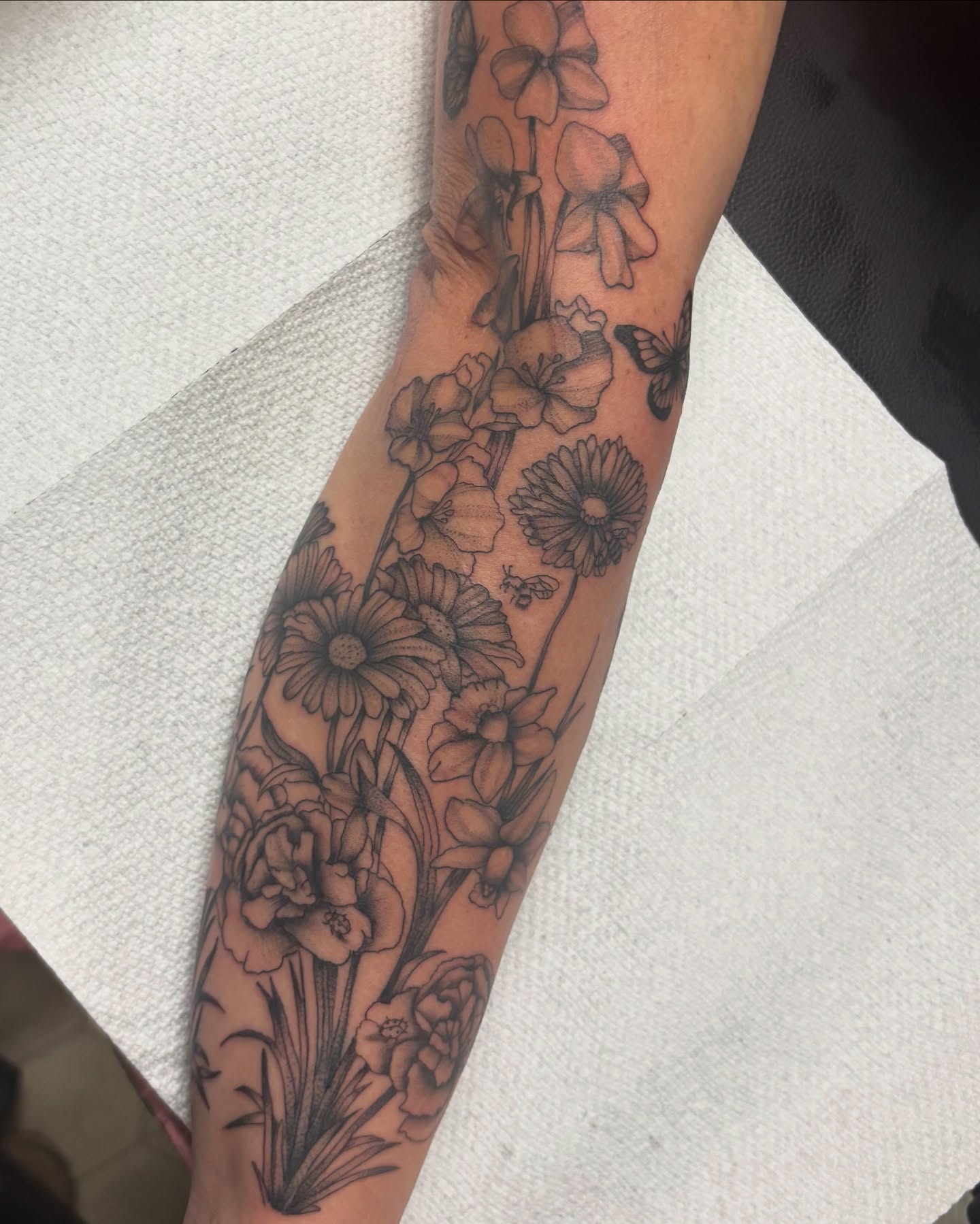 Floral bouquet black and grey tattoo on the forearm by Bridget Smith