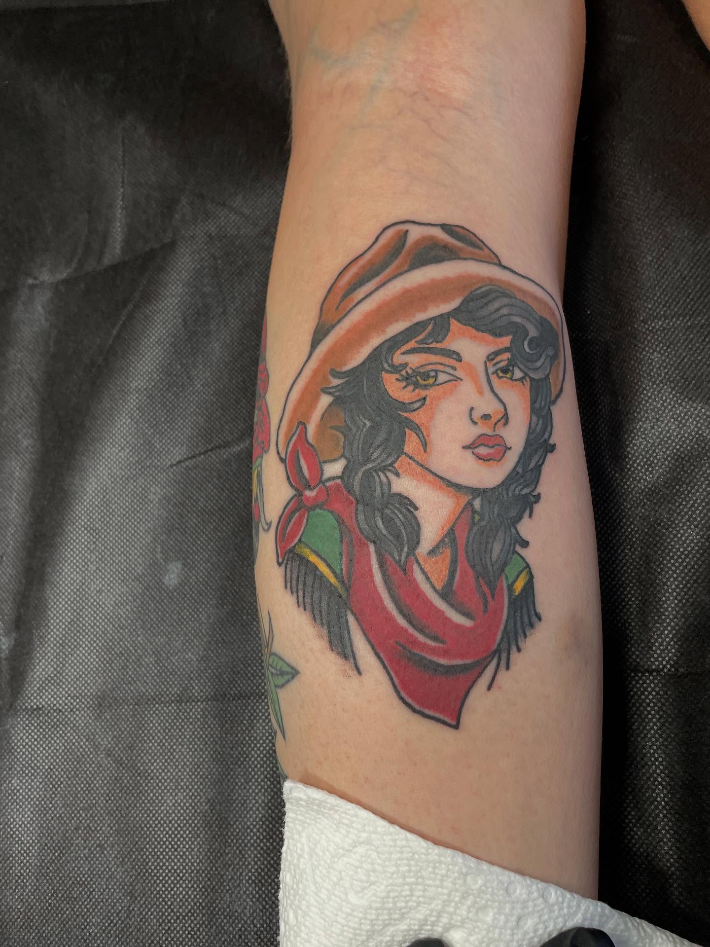 Woman wearing hat American traditional tattoo on the forearm by Mark Johnson [Tattoo Artist]