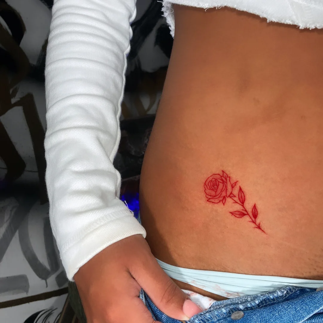 Rose fine line tattoo on the torso by Alvaro