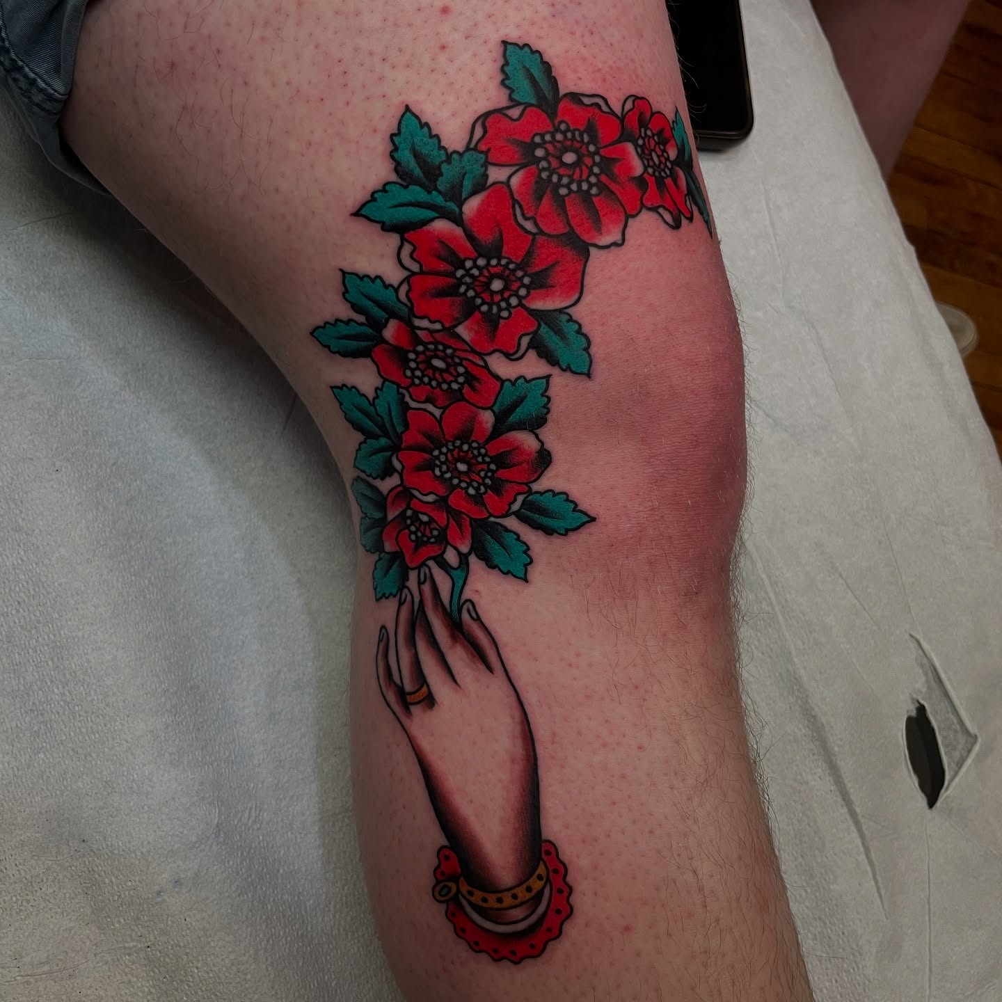 Hand with flowers American traditional tattoo on the forearm by Texas Jonah