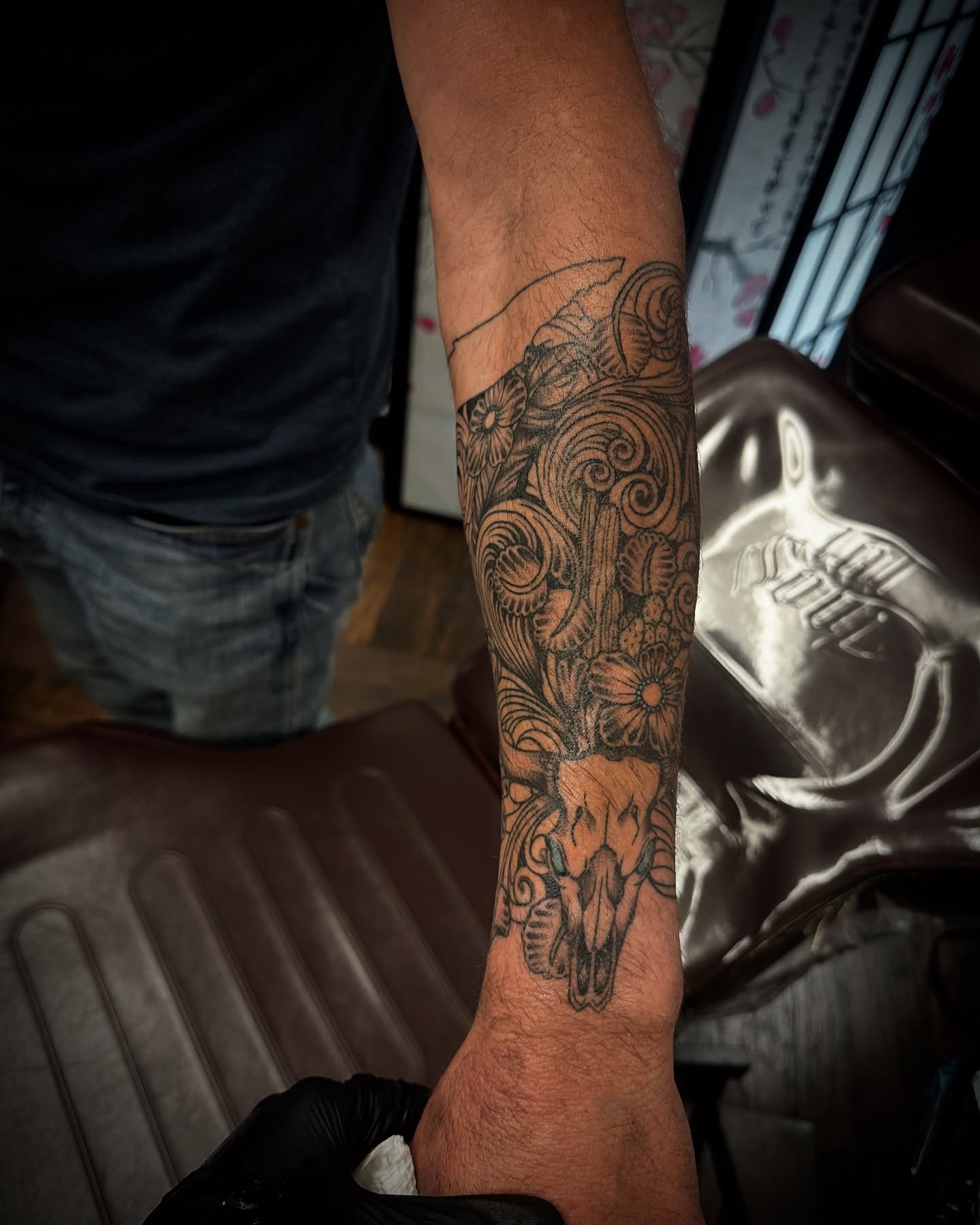 Skull and floral ornamental tattoo on the forearm by Kassie Perian