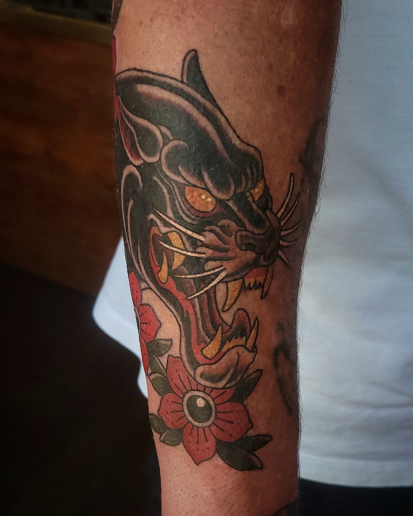 Panther and flowers American traditional tattoo on the forearm by Sean Hollinger