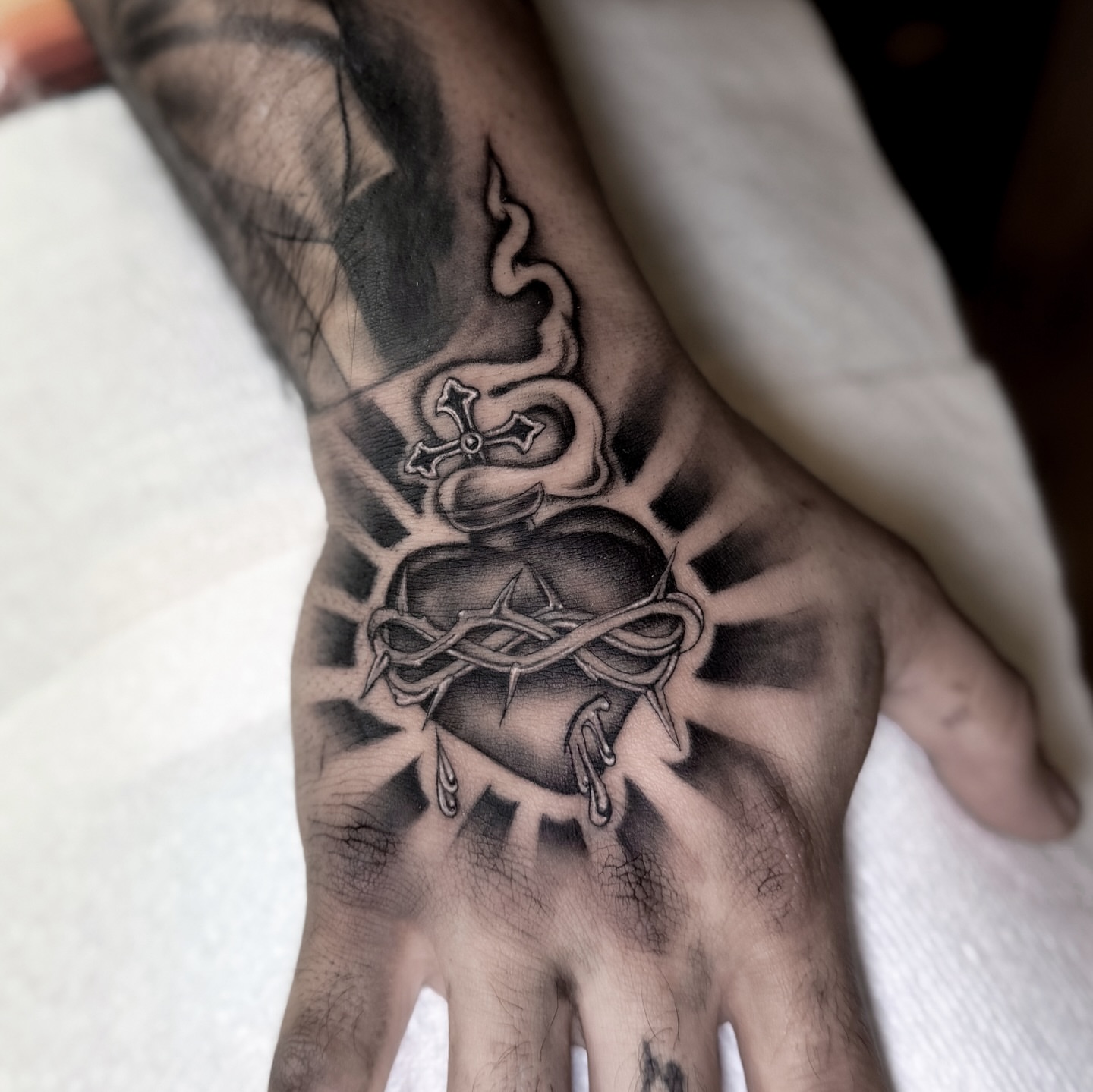 Heart with crown of thorns realism tattoo on the hand by @sadfoo_tattoo, Austin, Texas
