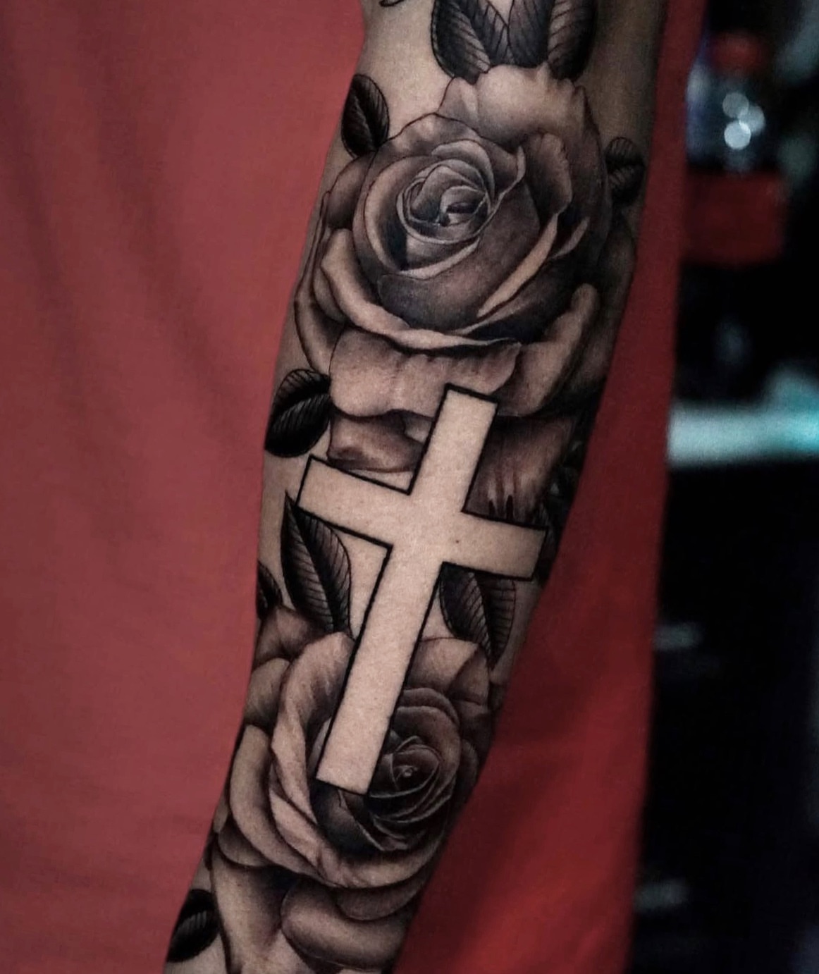 Cross and roses black and grey tattoo on the forearm by Johnson