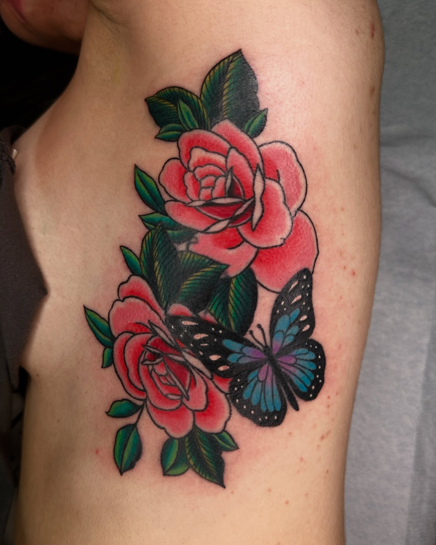 Roses and butterfly American traditional tattoo on the upper arm by Jared, Addison, Texas