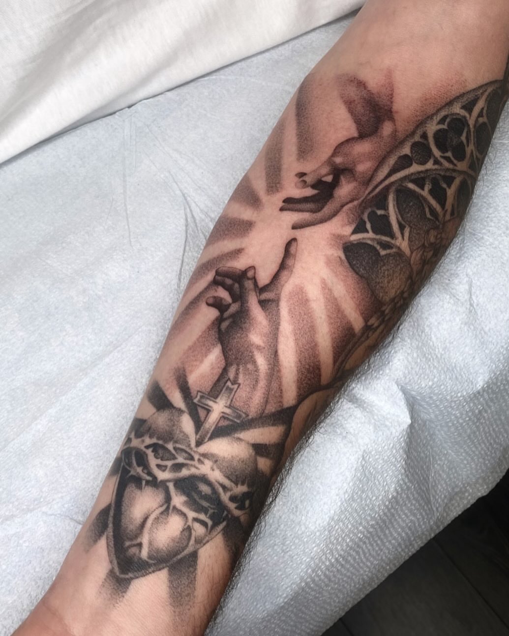 Heart and hands realism tattoo on the forearm by Cody Mason