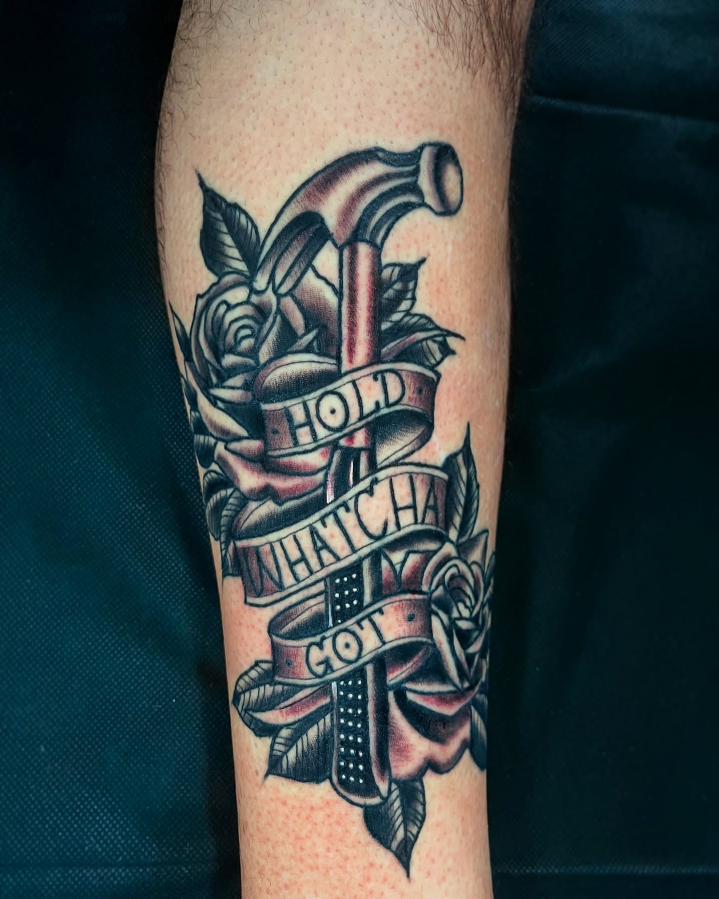 Hammer and roses American traditional tattoo on the forearm by Gilbert Gonzalez