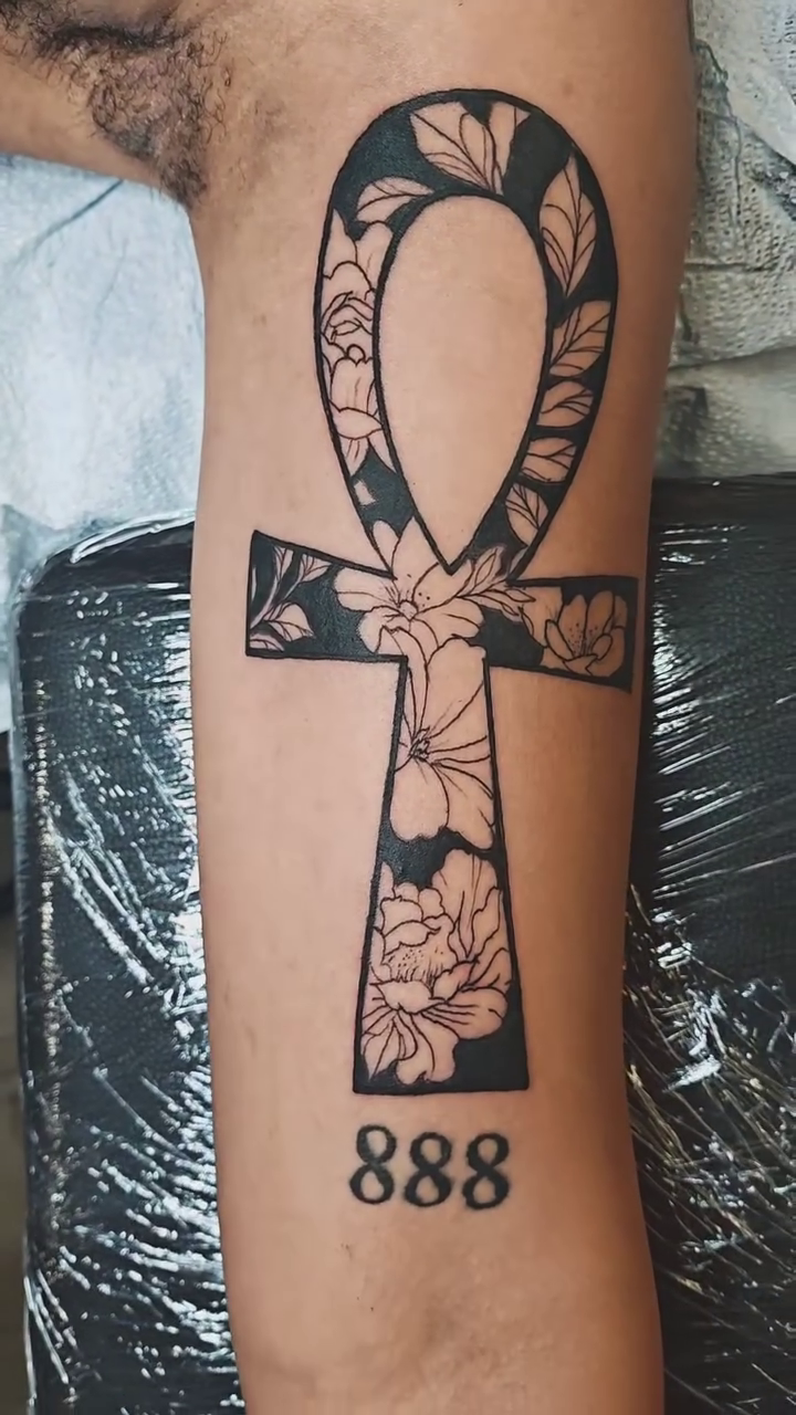 Ankh with floral pattern and numbers ornamental tattoo on the upper arm by @cvpital