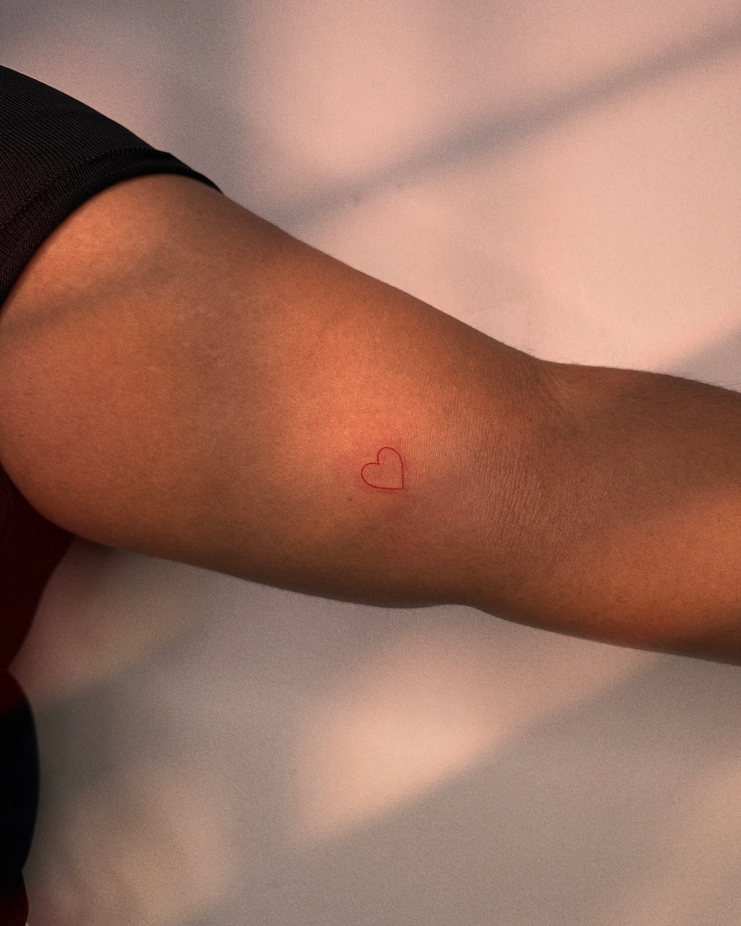 Heart fine line tattoo on the forearm by Ellie