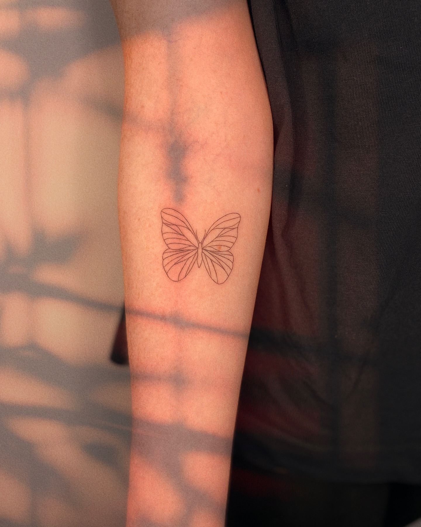 Butterfly fine line tattoo on the forearm by Ellie