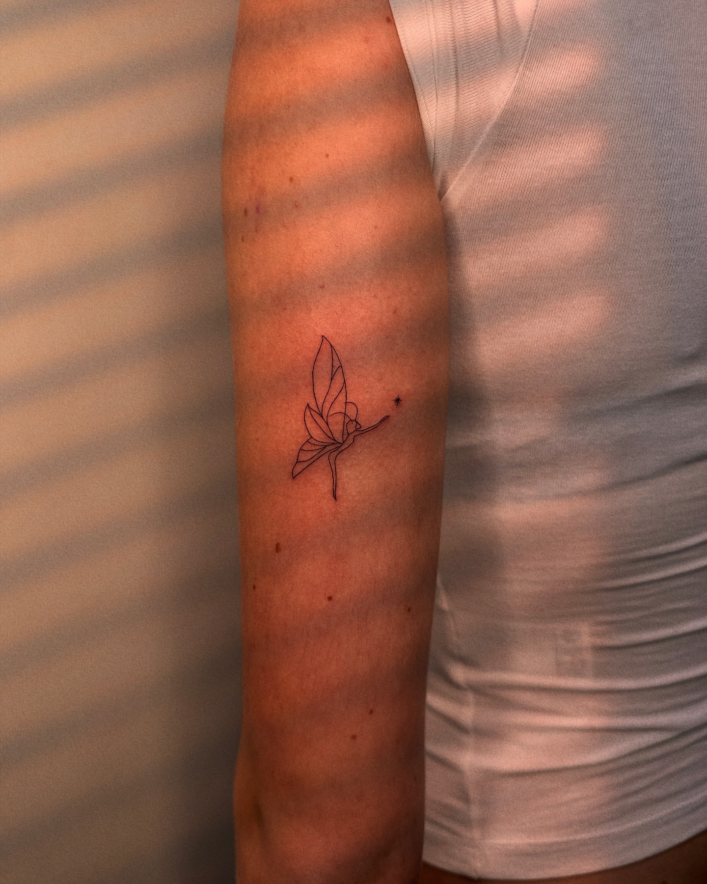 Butterfly fine line tattoo on the forearm by Ellie