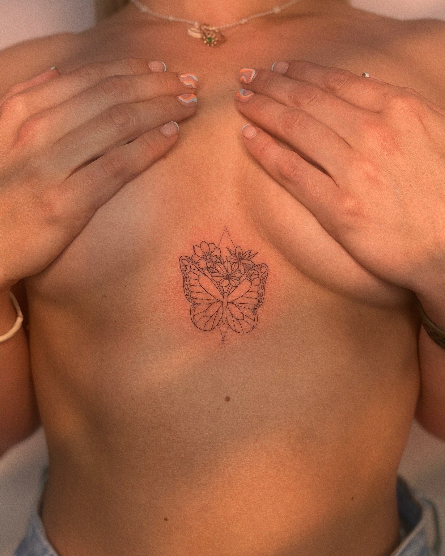 Butterfly and flowers fine line tattoo on the chest by Ellie