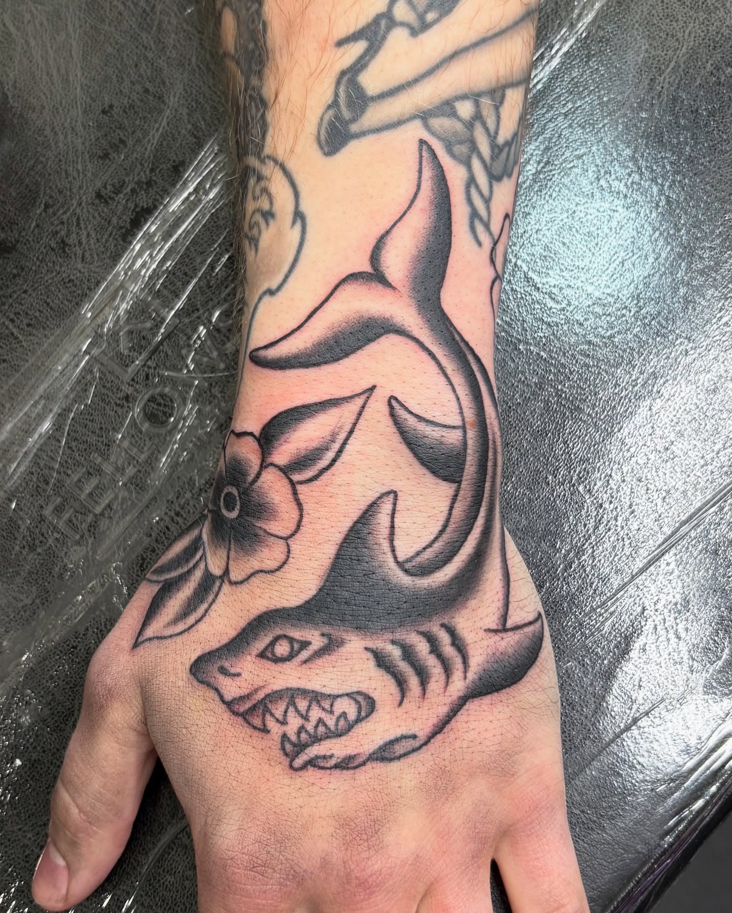Shark and flower American traditional tattoo on the hand by Jamie Yuu, Minneapolis, Minnesota