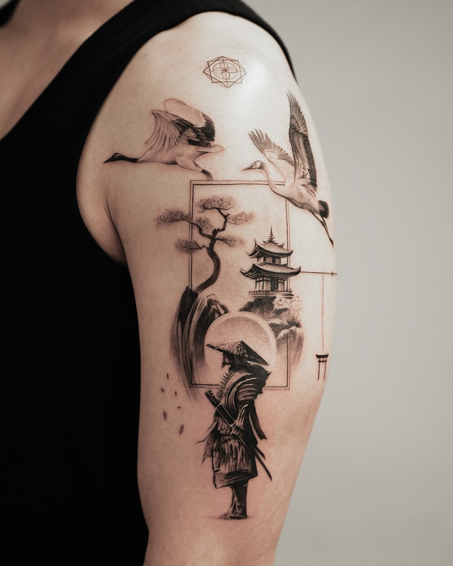Japanese-inspired landscape realism tattoo on the upper arm by Kid Needle