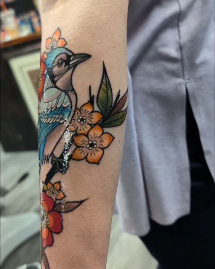 Bird and flowers American traditional tattoo on the forearm by Kara Falcon