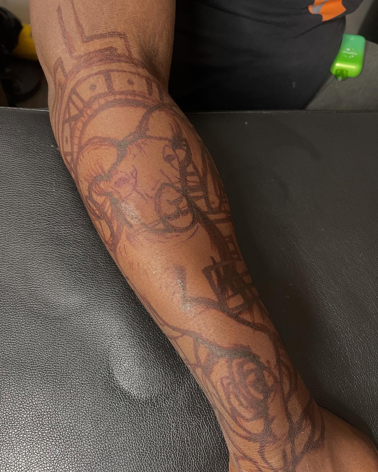 Lion and roses black and grey tattoo on the forearm by Azaan (Zanye), Birmingham, Alabama