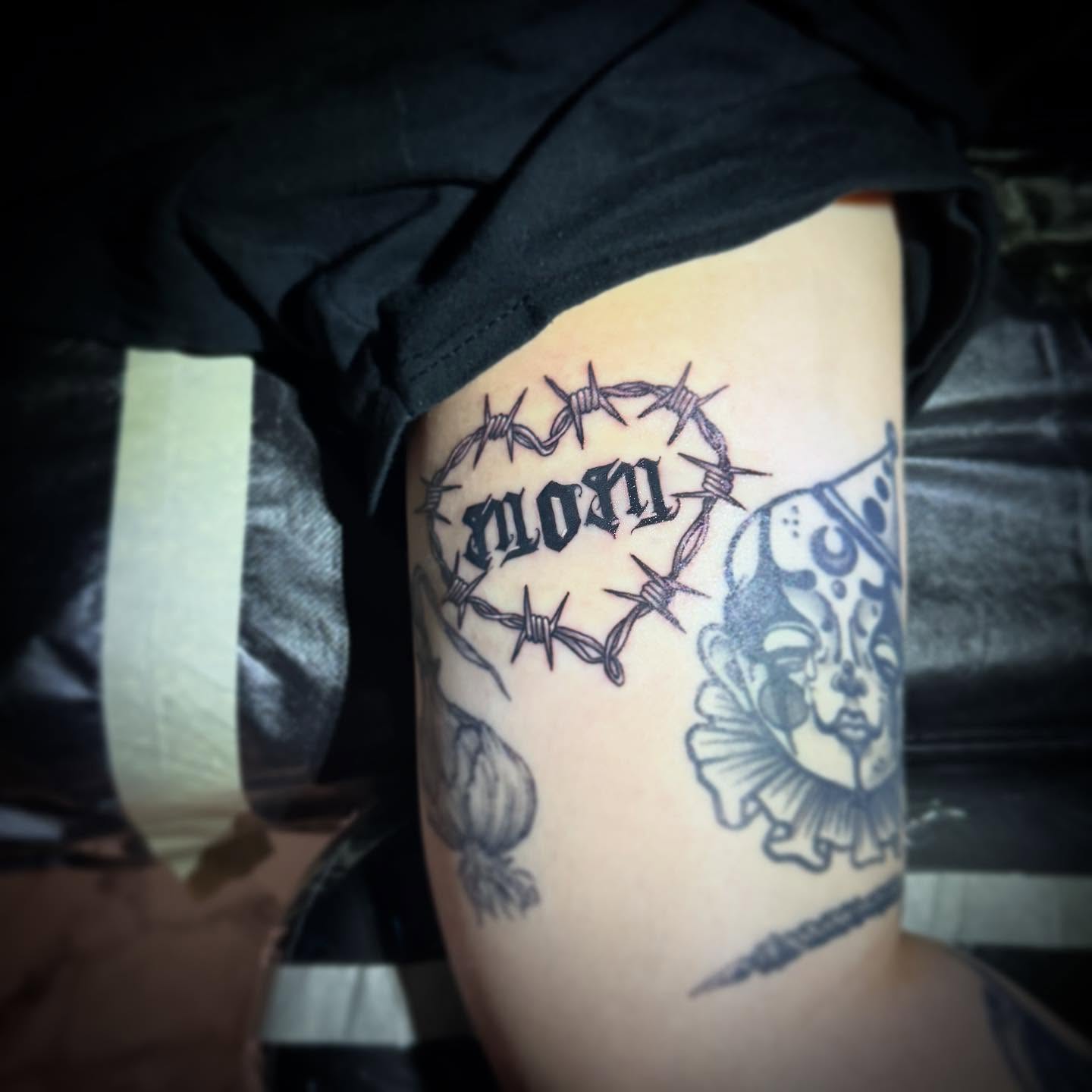 Barbed wire and clown black and grey tattoo on the thigh by AaronAdlerTattoos.com, Cincinnati