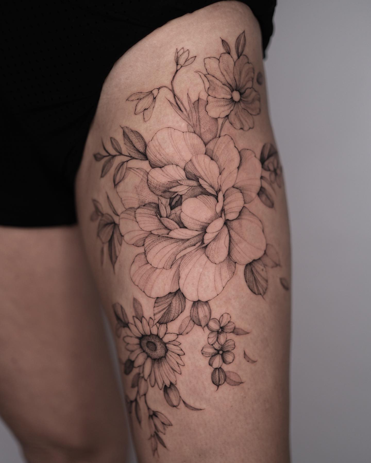 Floral bouquet black and grey tattoo on the thigh by Tattoo artist in Boston
