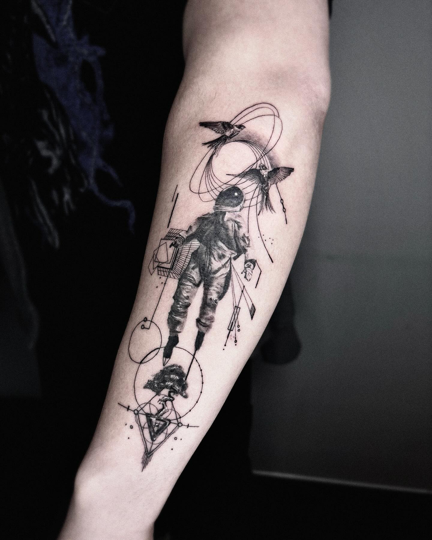 Astronaut with birds dotwork tattoo on the forearm by Seraph Geometry