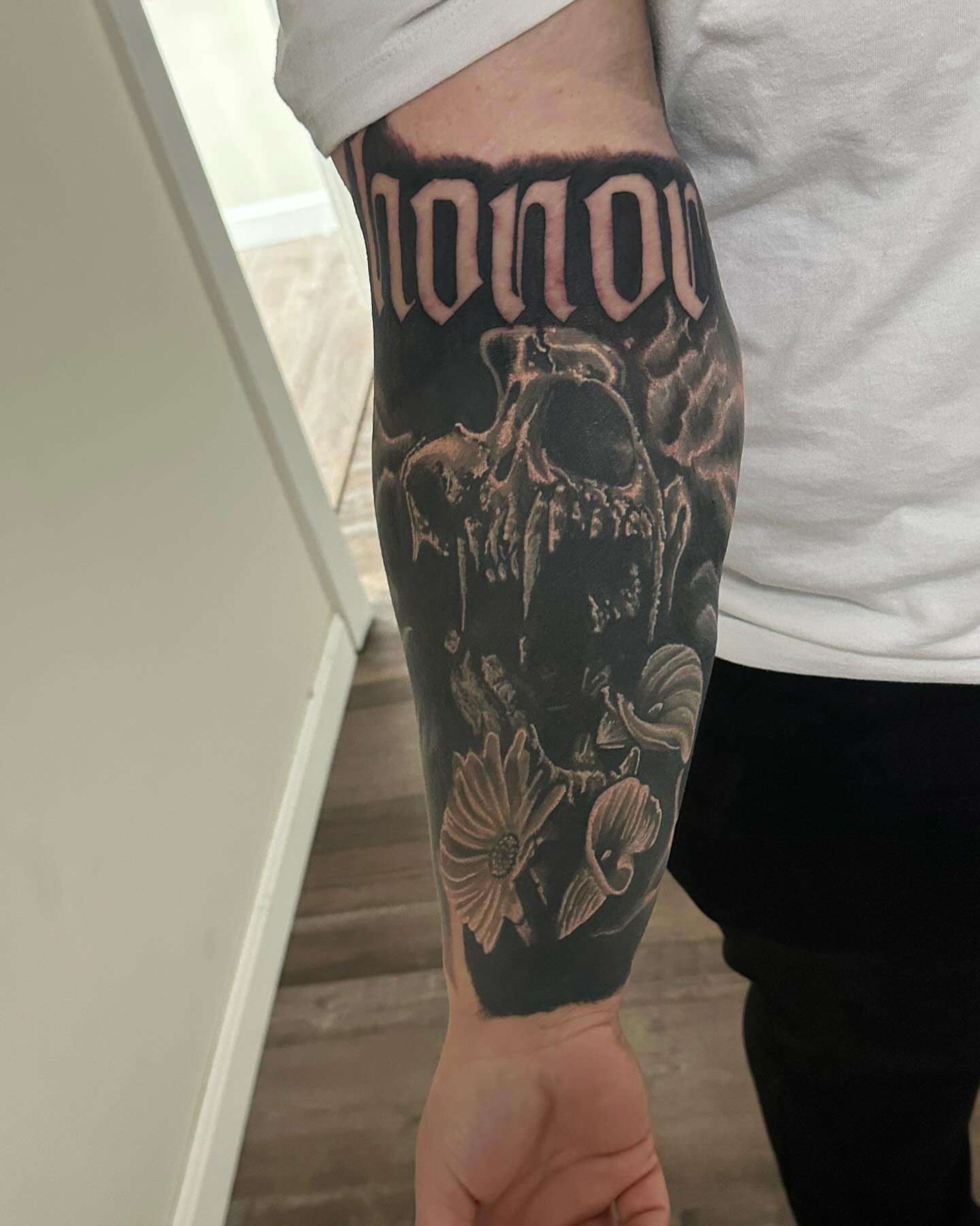 Skull and flowers dark realism tattoo on the forearm by Neil5one3
