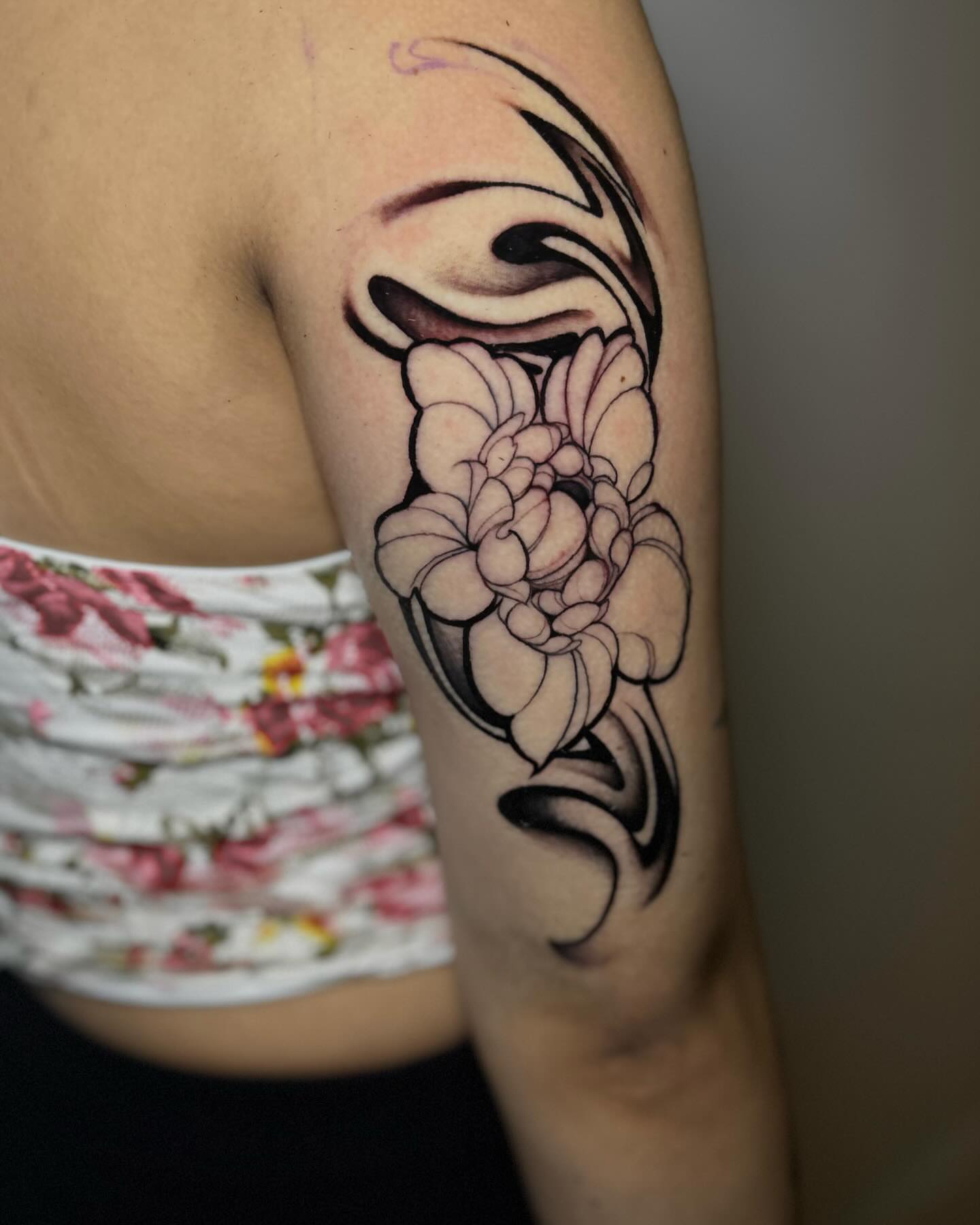 Floral design black and grey tattoo on the upper arm by orlando