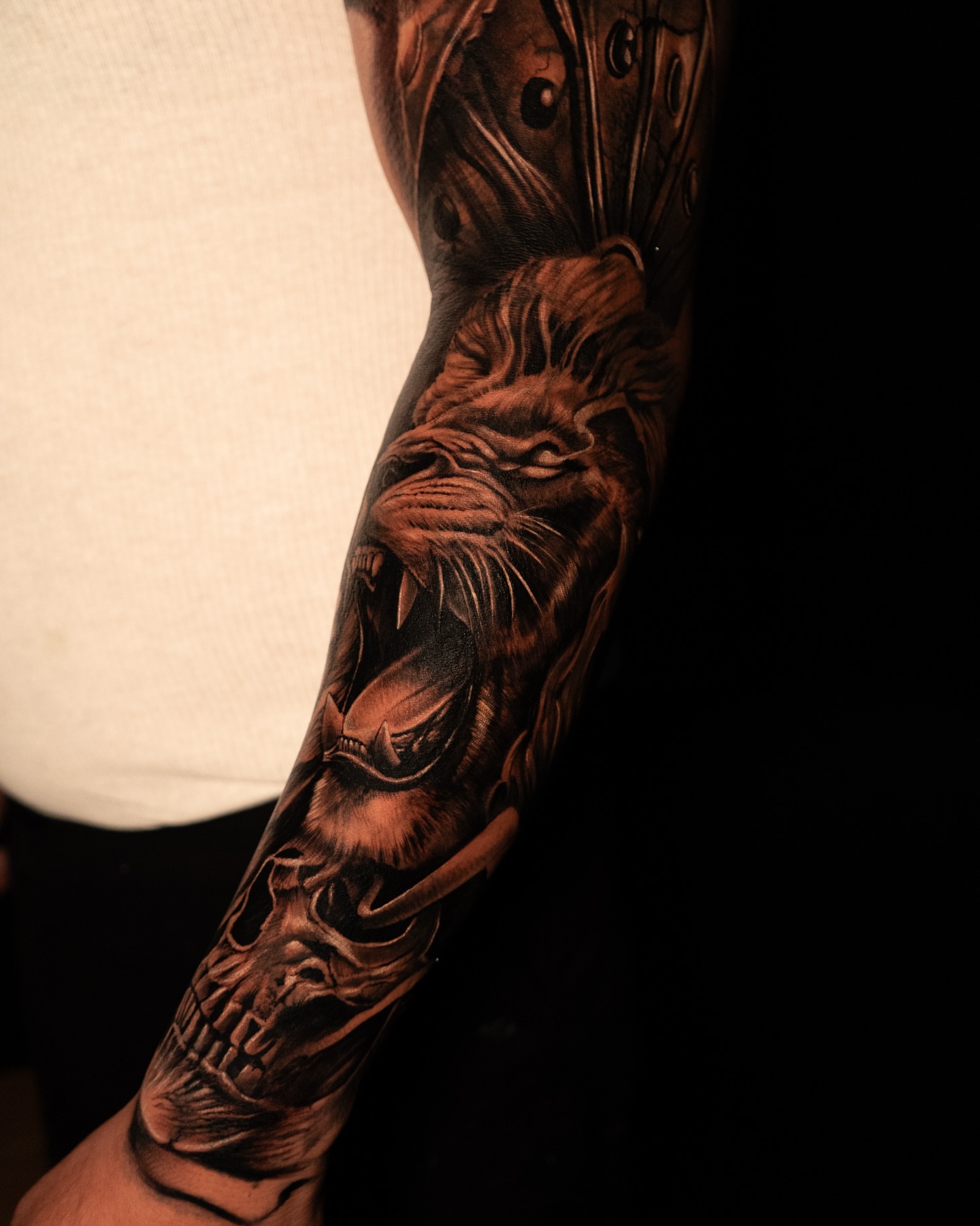 Skull and lion realism tattoo on the forearm by Apolo