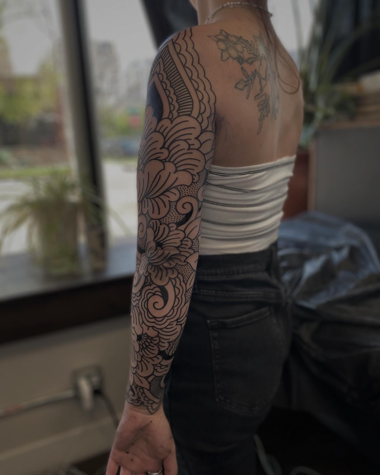 Floral pattern black and grey tattoo on the upper arm by Veronica