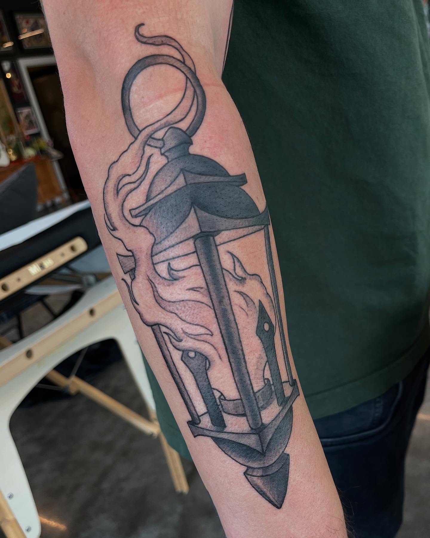 Anchor with flame black and grey tattoo on the forearm by Ian White