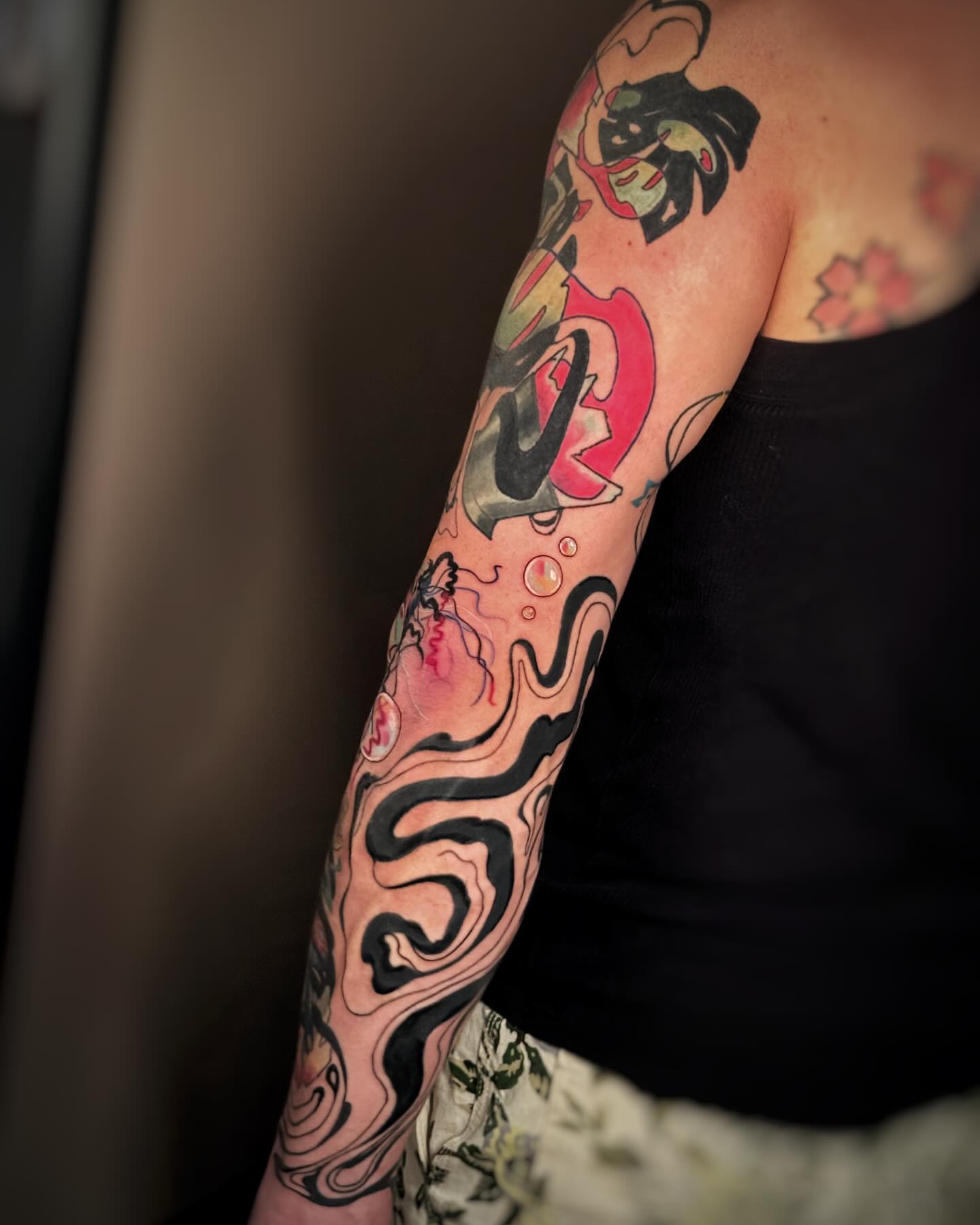 Abstract fluid design watercolor tattoo on the upper arm by Anna Saveria