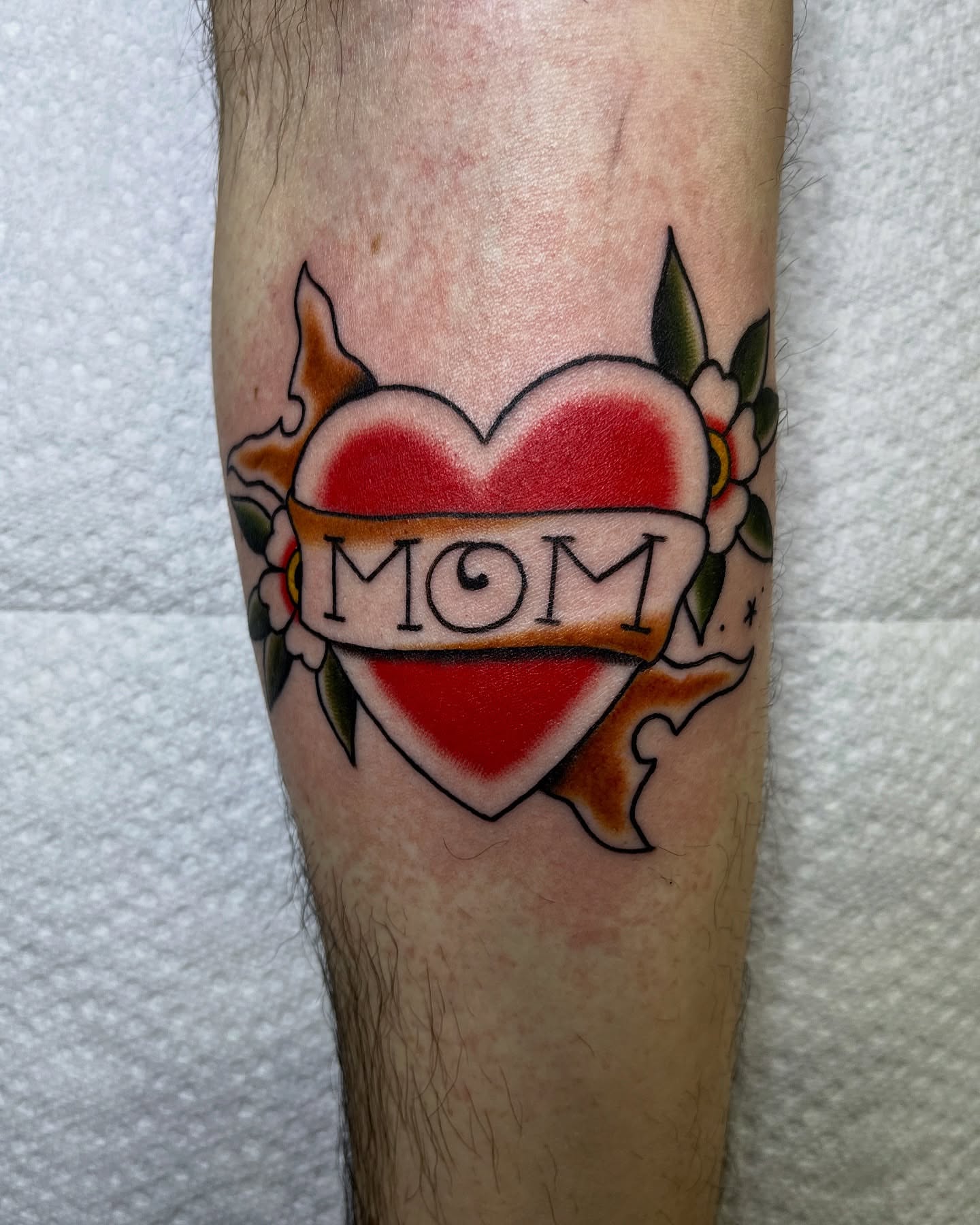 Heart with 'mom' American traditional tattoo on the forearm by Pedroux M.
