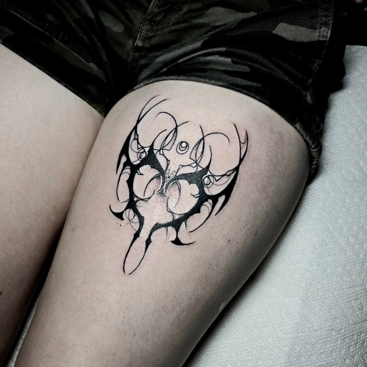 Abstract design black and grey tattoo on the thigh by Ema Fish
