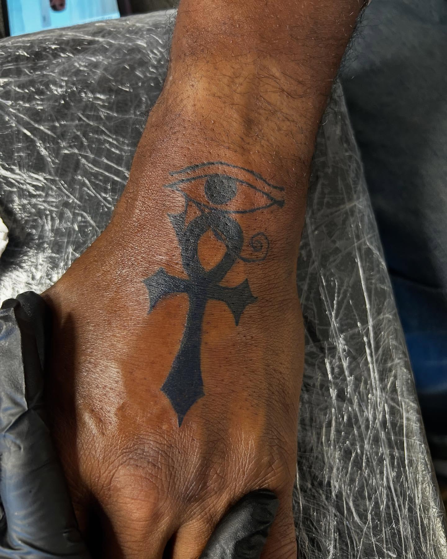 Eye and ankh black and grey tattoo on the hand by Airika Edwards